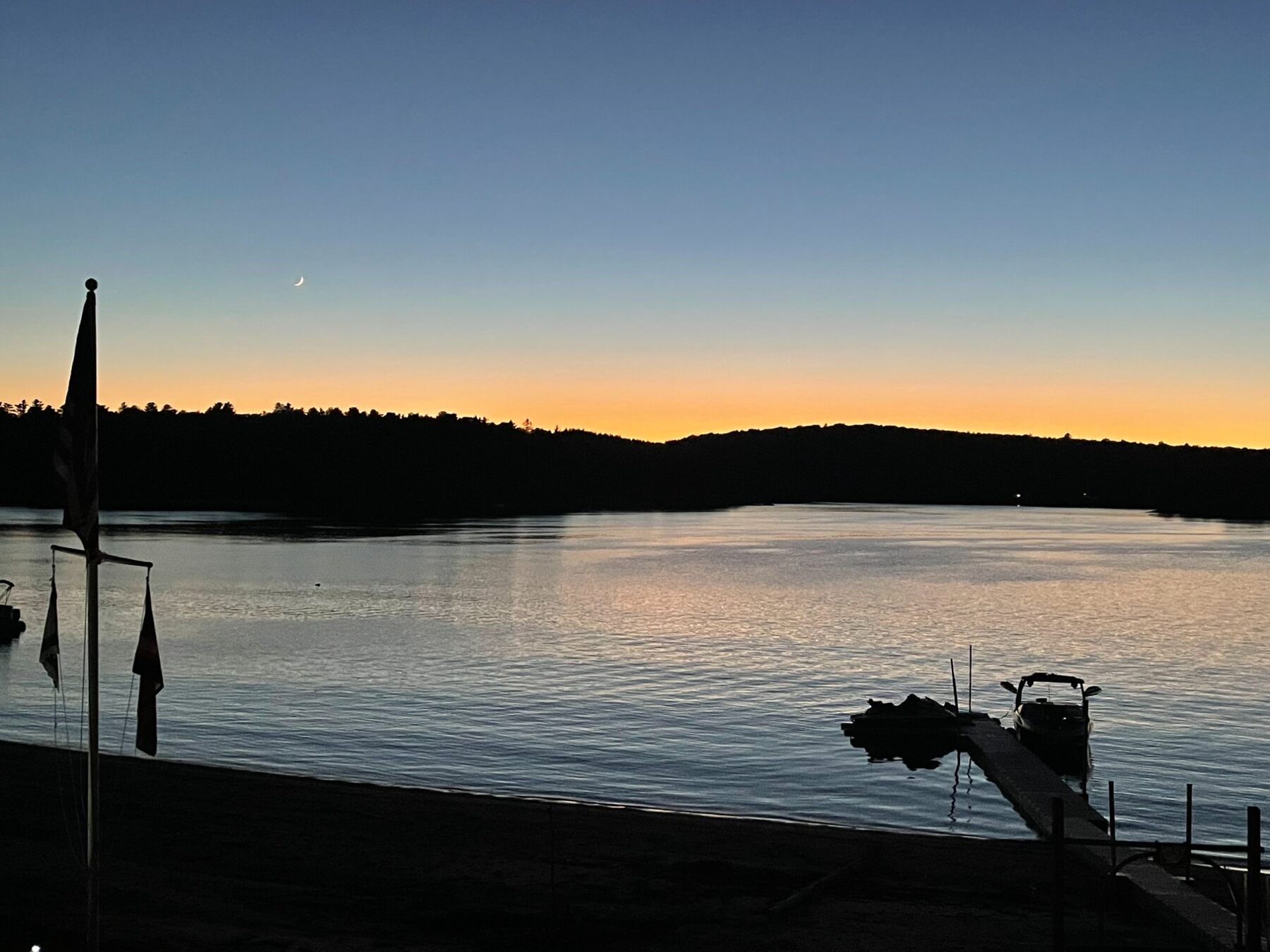 Twilight over the lake with crescent moon